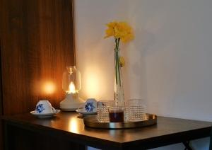 a table with a vase with a yellow flower in it at Sládkovičov dvor in Banská Štiavnica
