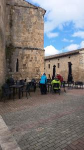 a group of people sitting at tables in front of a building at Fuentestrella in Hontanas