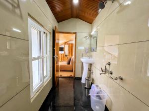 a bathroom with a sink and a toilet and a window at Vamitag Inn in Shimla +125 photos