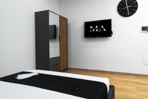 a room with a bed and a mirror and a clock at MEA Suite in Palermo
