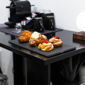 a table with three pastries on a black plate at MEA Suite in Palermo