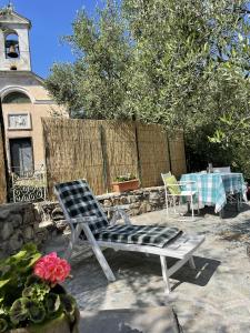 a patio with a chair and a table and a fence at Piccola Navetta in Diano San Pietro