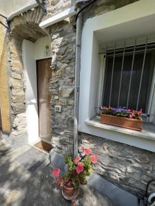 a window with two flower pots on the side of a building at Piccola Navetta in Diano San Pietro