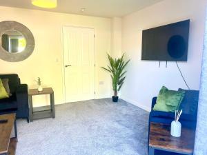 a living room with a blue couch and a tv at Earl House in Coxhoe