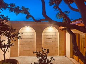 a building with three arches on the side of it at Masseria La Millenaria in San Foca