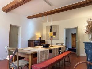 a dining room with a table and chairs in a room at Les Terrasses de Ventabren in Ventabren