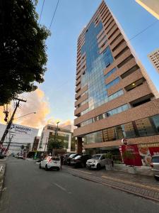 a tall building with cars parked in a parking lot at GUEST Manaíra Shopping in João Pessoa