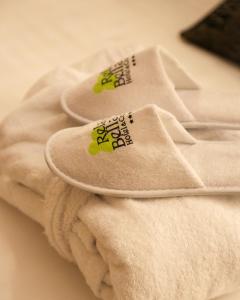 a pair of white slippers sitting on a pile of towels at Relais Bellaria Hotel & Congressi in Bologna