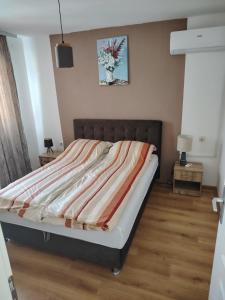 a bedroom with a bed with a striped blanket on it at Vila Oaza mira in Vražići