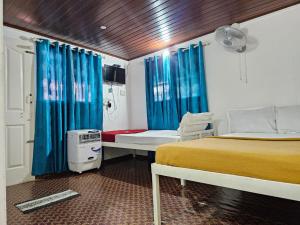 a bedroom with a bed with blue drapes at Bamboo leaf Homestay in Meppādi
