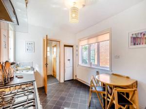 eine Küche mit Tisch und Herd und Fenster in der Unterkunft Large 5 Bed House in Scarborough near the beach, Large Garden & HOT TUB in Scarborough