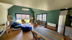 ヴール・レ・ローズにあるConfort détente près de la plageの緑の壁のリビングルーム(ベッド、椅子付)