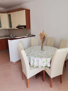 a dining room table and chairs with a tablecloth on it at Apartmani BISERKA in Šibuljina
