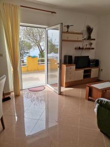 a living room with a sliding glass door at Apartmani BISERKA in Šibuljina +5 photos