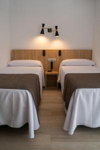a hotel room with two beds and a lamp at Sunside Ibiza Studios - Only Adults- Formerly known as Central Park in San Antonio