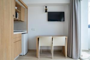 a small kitchen with a table and a television at Sunside Ibiza Studios - Only Adults- Formerly known as Central Park in San Antonio