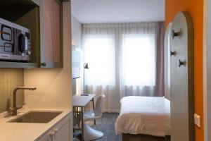 a room with a bed and a kitchen with a sink at HUB Apartments St Georg in Hamburg