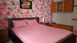 a bedroom with a pink bed with a wall with roses at Imanta Apartment Riga 2х Rooms 52м2 in Rīga