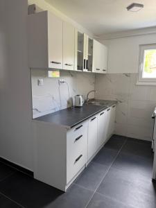 a kitchen with white cabinets and a sink at Apartman A&A in Sarajevo