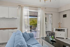 Una sala de estar con un sofá azul y una mesa. en Krasna kuća, en Labin