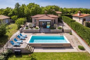 Una piscina en un patio con sillas y una casa. en Krasna kuća, en Labin
