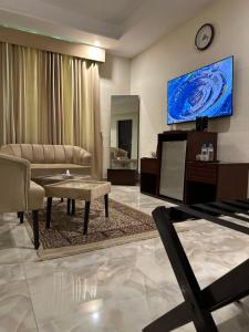a living room with a couch and a tv at Burj Ul Zaki in Islamabad