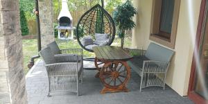 a patio with a table and chairs and a wheel at Domek Zielenina in Mierzeszyn