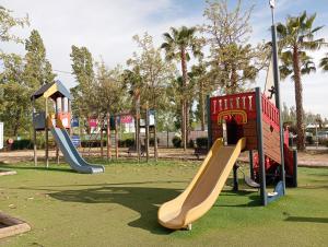 a playground with two slides in a park at Mobil-Home le Montourey in Fréjus