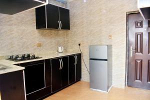 a kitchen with a white refrigerator in a room at Ikeserviceapartment in Owerri