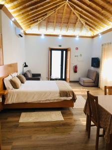 a bedroom with a large bed and a living room at AMU- Apartamentos Mistérios da Urzelina in Urzelina +53 photos