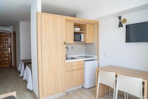 a small kitchen with a sink and a microwave at Sunside Ibiza Studios - Only Adults- Formerly known as Central Park in San Antonio