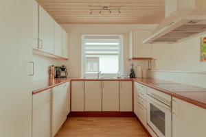 a kitchen with white cabinets and a window at Apartment with Balcony and Ocean View - Tórshavn in Tórshavn