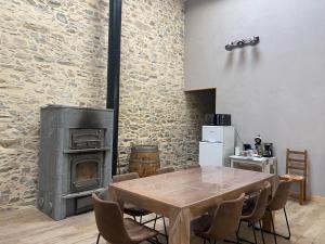 a kitchen with a wooden table and a wood stove at LA GRANDE THIBAUDIERE in La Plaine