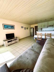 a living room with a couch and a tv at Plage et centre à 100m avec balcon et parking privé 4 pers in Saint-Brévin-lʼOcéan