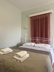 a bedroom with a bed with towels on it at Odysseas rooms in Kalón Nerón