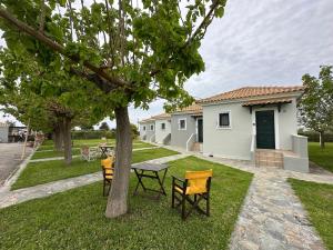 a yard with chairs and a table and a house at Odysseas rooms in Kalón Nerón
