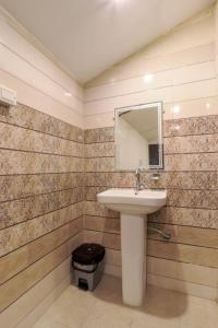a bathroom with a sink and a mirror at The Hill Mount Resort Shivpuri in Rishīkesh