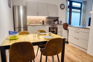 a kitchen with a table with chairs and a refrigerator at TheStationNest in Amberg