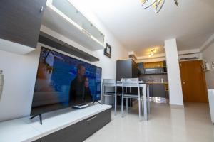 a living room with a large flat screen tv on the wall at La Rosa in Gran Tarajal