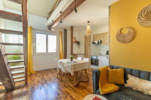 a living room with a couch and a table at Le Boho - Charmant T3 avec climatisation et fibre in Bergerac