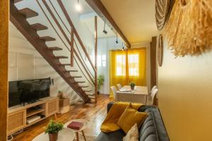 a living room with a couch and a tv at Le Boho - Charmant T3 avec climatisation et fibre in Bergerac