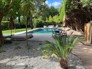a backyard with a pool and a table and chairs at La Réserve Villa in Aix-en-Provence