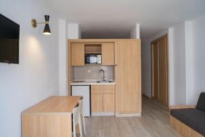 a small apartment with a kitchen and a table at Sunside Ibiza Studios - Only Adults- Formerly known as Central Park in San Antonio