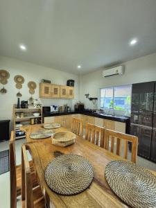 a kitchen with a wooden table with chairs and a tableasteryasteryasteryasteryastery at Villa Tsukino Usagi in Koh Phangan