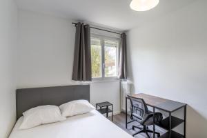 a bedroom with a bed and a desk and a window at Spacieux Appartement 4 Chambres in Hérouville-Saint-Clair