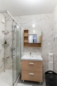 a bathroom with a sink and a glass shower at Spacieux Appartement 4 Chambres in Hérouville-Saint-Clair +22 photos