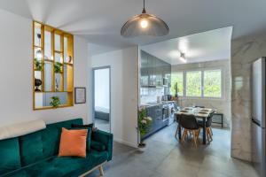 a living room with a green couch and a table at Spacieux Appartement 4 Chambres in Hérouville-Saint-Clair