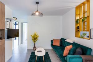 a living room with a green couch and a table at Spacieux Appartement 4 Chambres in Hérouville-Saint-Clair