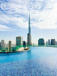 a infinity pool with a view of a city at New Luxury 2 Bedroom with Burj Khalifa View & Spectacular Rooftop Infinity Pool Bar in Dubai +50 photos