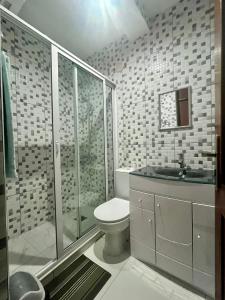 a bathroom with a toilet and a glass shower at Oásis de retour in Ponta do Sol